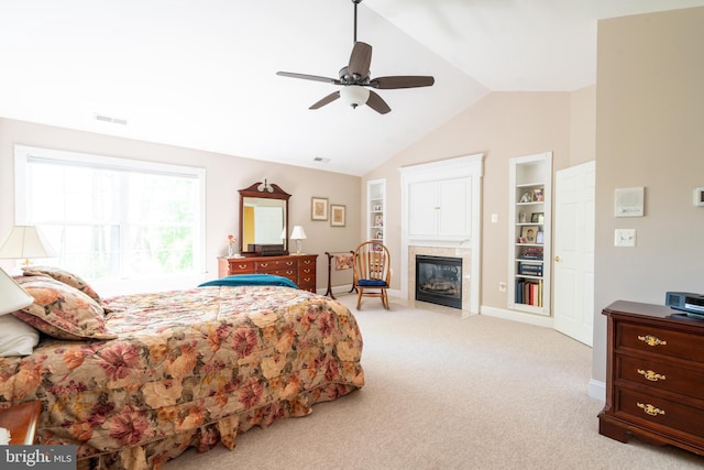 carpeted bedroom with visible vents, baseboards, ceiling fan, a fireplace with flush hearth, and vaulted ceiling