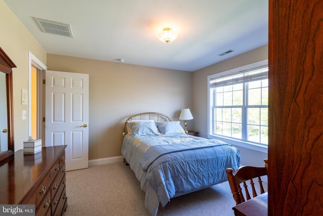 bedroom featuring baseboards, light carpet, and visible vents
