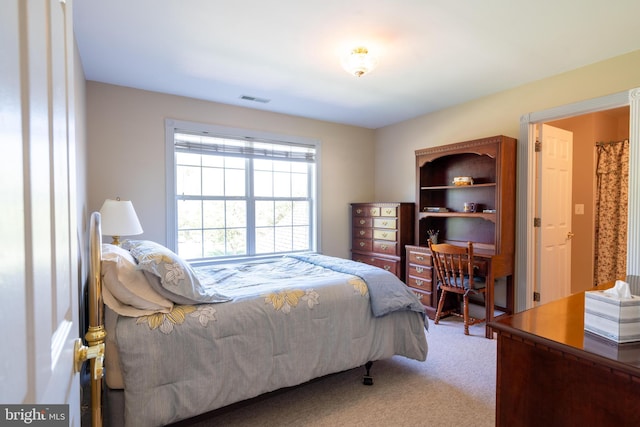 carpeted bedroom featuring visible vents