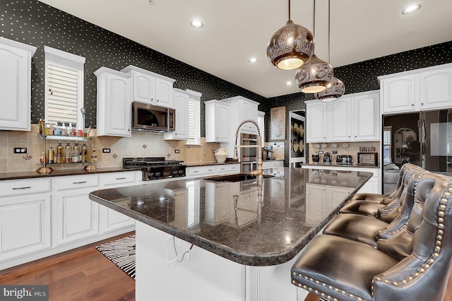 6206 Payton Way, Frederick, MD 21703 - kitchen featuring a sink, a breakfast bar, wallpapered walls, white cabinets, and stainless steel microwave