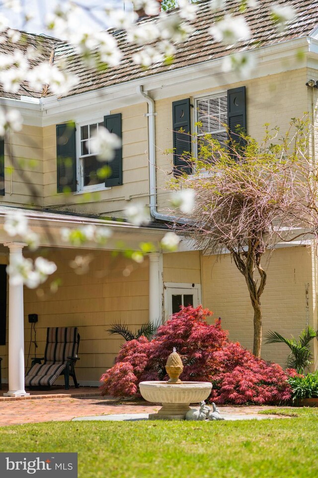 exterior details with gutters, a downspout, and brick siding