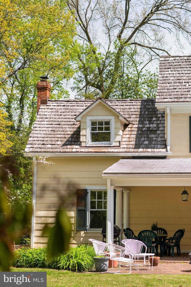 rear view of house featuring a patio area and a chimney