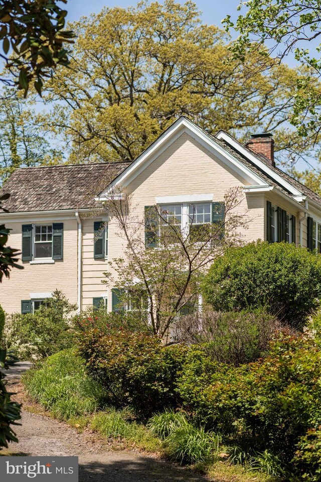 view of home's exterior featuring brick siding and a chimney