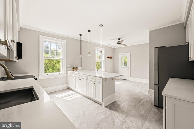 kitchen with ornamental molding, a peninsula, and a wealth of natural light