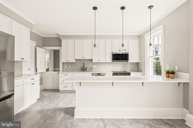 kitchen featuring crown molding, freestanding refrigerator, a breakfast bar area, tasteful backsplash, and range with electric cooktop