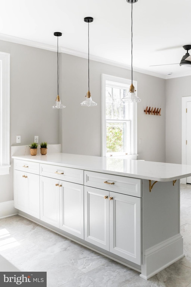 bar featuring pendant lighting, baseboards, and ornamental molding