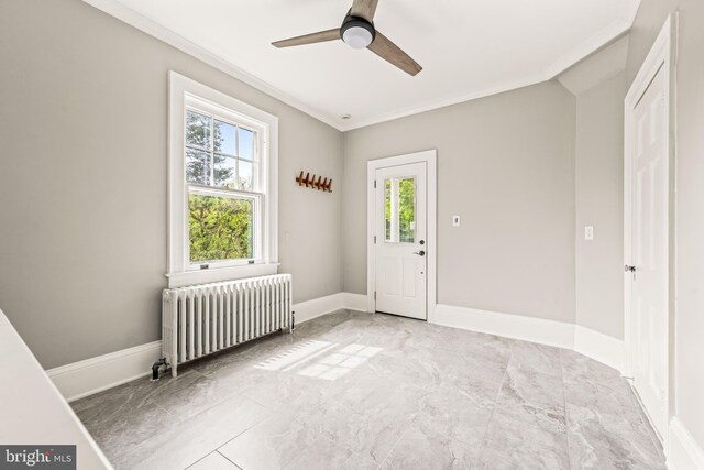 interior space with ceiling fan, radiator heating unit, marble finish floor, baseboards, and ornamental molding