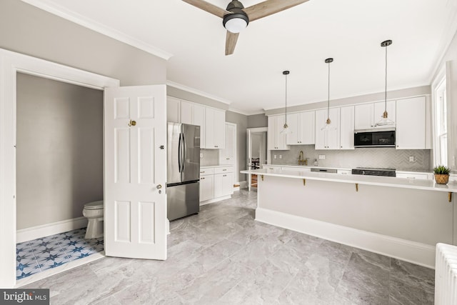 kitchen featuring crown molding, white cabinets, hanging light fixtures, appliances with stainless steel finishes, and light countertops