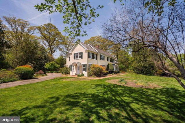 view of front of property with a chimney and a front yard