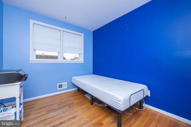 bedroom featuring wood finished floors and baseboards