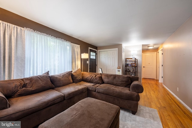 living area with light wood-style flooring and baseboards