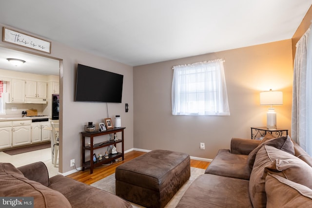 living room featuring light wood finished floors and baseboards