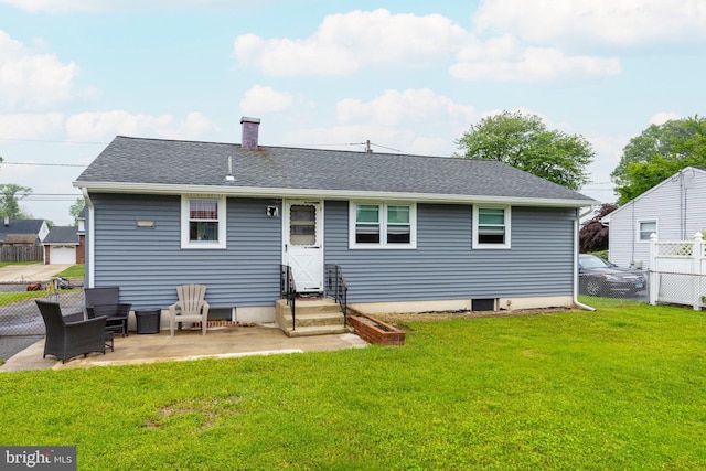 rear view of house with a patio area, a chimney, entry steps, and roof with shingles