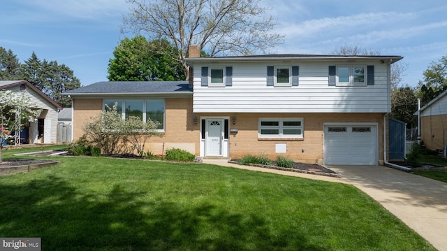 split level home featuring brick siding, a chimney, a front yard, and a garage