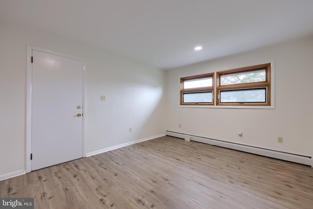 unfurnished room with baseboards, a baseboard heating unit, recessed lighting, and wood finished floors