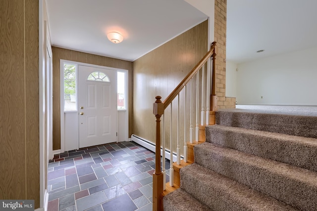 entrance foyer with a baseboard radiator, stairs, and stone tile flooring