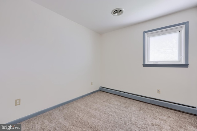 carpeted empty room with baseboards, a baseboard heating unit, and visible vents