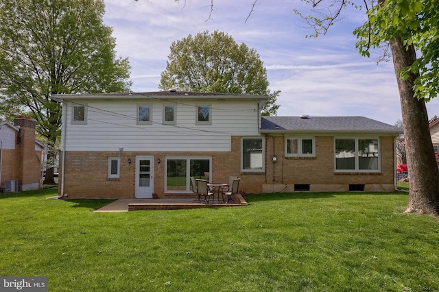 rear view of property with a lawn, a patio, and brick siding
