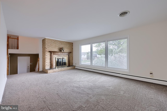 unfurnished living room with carpet floors, a fireplace, a baseboard heating unit, and visible vents