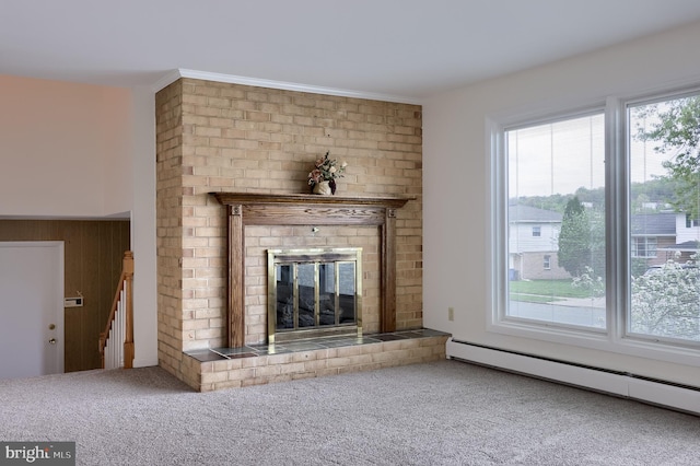 unfurnished living room with a fireplace, a baseboard radiator, carpet, and stairs