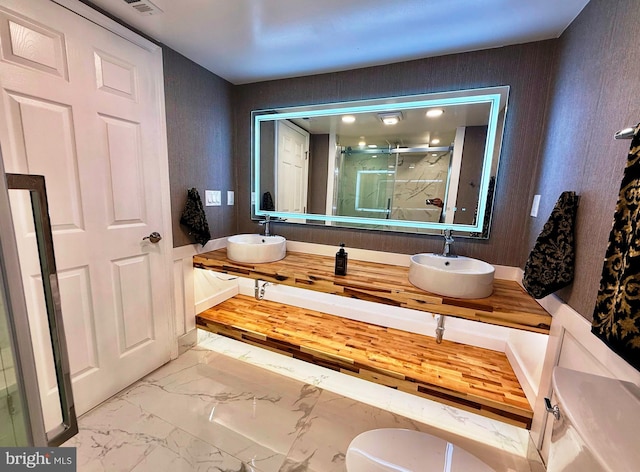 9905 Stoughton Rd, Fairfax, VA 22032 - bathroom with a shower stall, marble finish floor, double vanity, and a sink