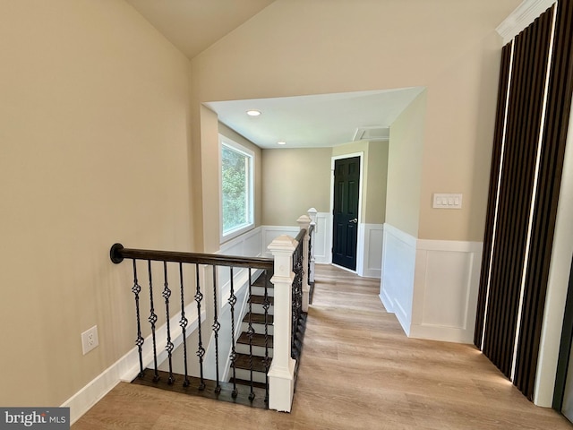 9905 Stoughton Rd, Fairfax, VA 22032 - hallway featuring lofted ceiling, light wood finished floors, an upstairs landing, and a wainscoted wall