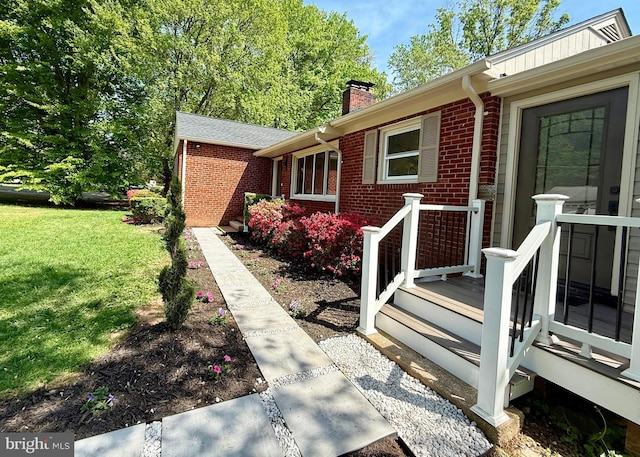9905 Stoughton Rd, Fairfax, VA 22032 - view of home's exterior with a chimney, a deck, brick siding, and a lawn