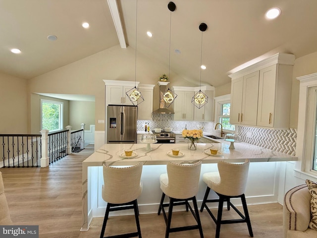 9905 Stoughton Rd, Fairfax, VA 22032 - kitchen with light stone counters, wall chimney exhaust hood, beamed ceiling, stainless steel appliances, and tasteful backsplash