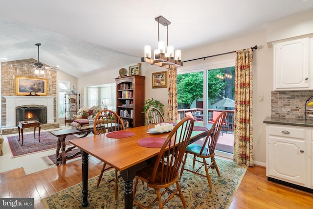 3635 Wessex Ln, Huntingtown, MD 20639 - dining room featuring a ceiling fan, light wood-style flooring, vaulted ceiling, and a brick fireplace