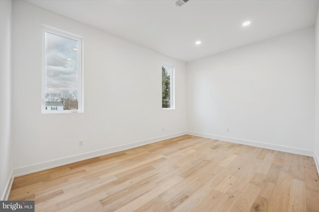 empty room with recessed lighting, light wood-style flooring, and baseboards
