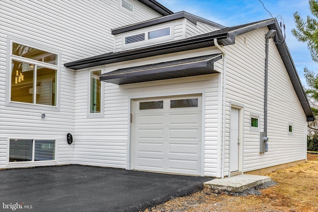 view of home's exterior featuring a garage and driveway