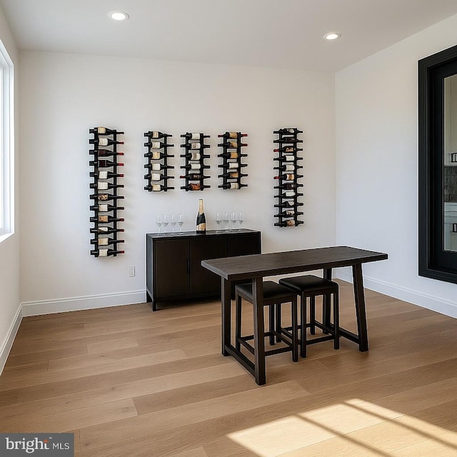 wine room with recessed lighting, baseboards, and light wood-type flooring