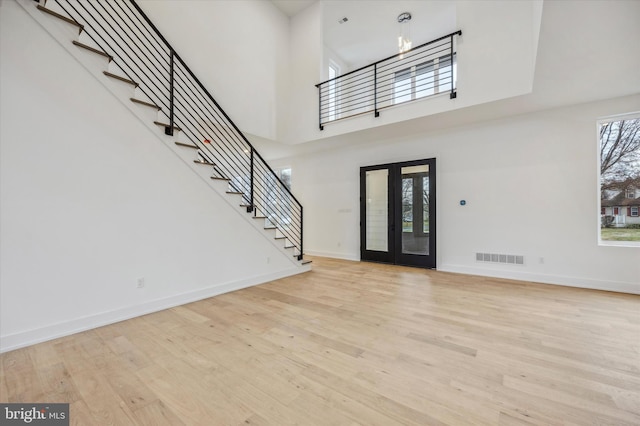 entrance foyer featuring baseboards, stairs, wood finished floors, and visible vents