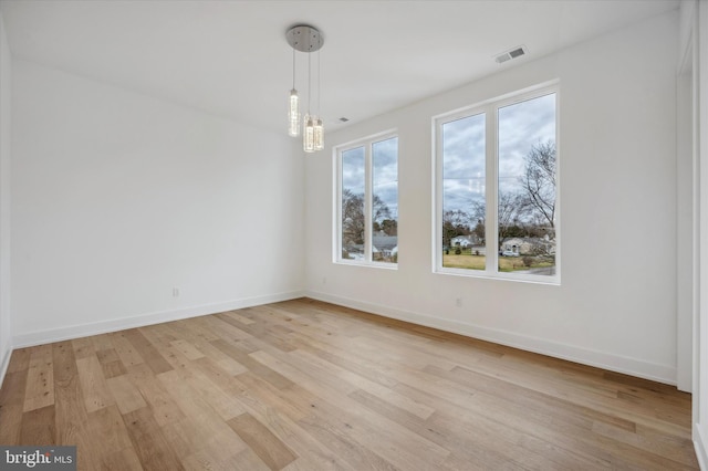 unfurnished dining area featuring baseboards, visible vents, and light wood finished floors