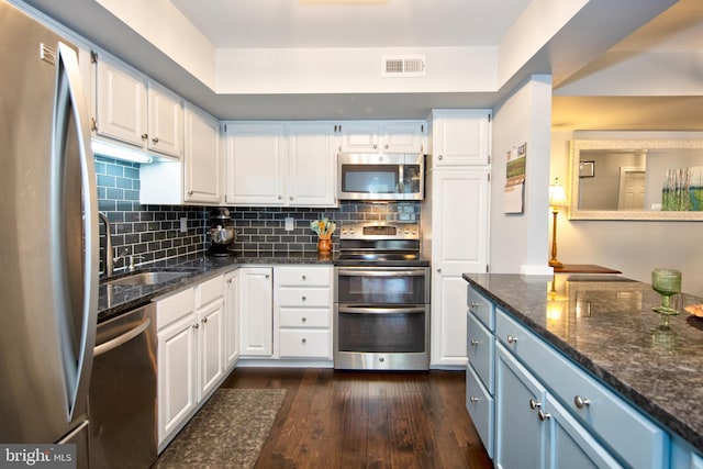 904 Martell Ct Unit 904-E, Bel Air, MD 21014 - kitchen featuring stainless steel appliances, white cabinets, dark wood-style flooring, decorative backsplash, and dark stone counters