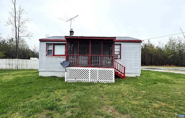 back of house featuring a sunroom, fence, and a yard