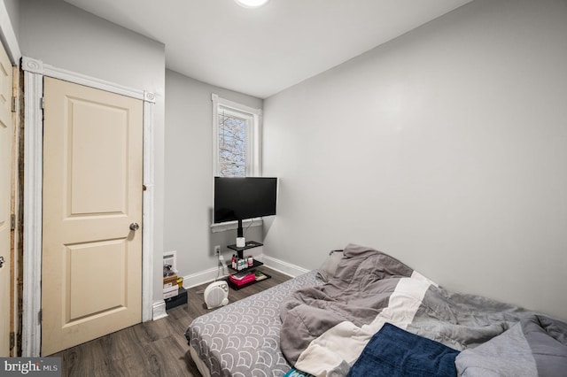 bedroom featuring baseboards and dark wood-style floors