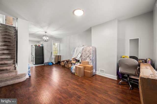 office space with a notable chandelier, baseboards, visible vents, and wood finished floors