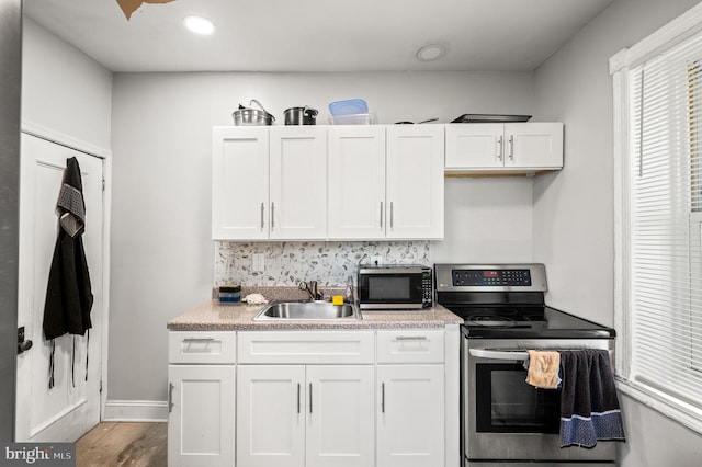 kitchen with light countertops, a sink, white cabinetry, and stainless steel appliances