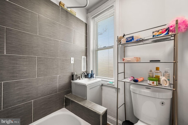 full bathroom with a sink, toilet, and a washtub