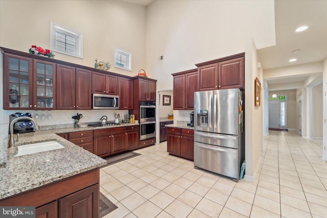 44516 Blueridge Meadows Dr, Ashburn, VA 20147 - kitchen featuring a sink, appliances with stainless steel finishes, a high ceiling, and light tile patterned flooring