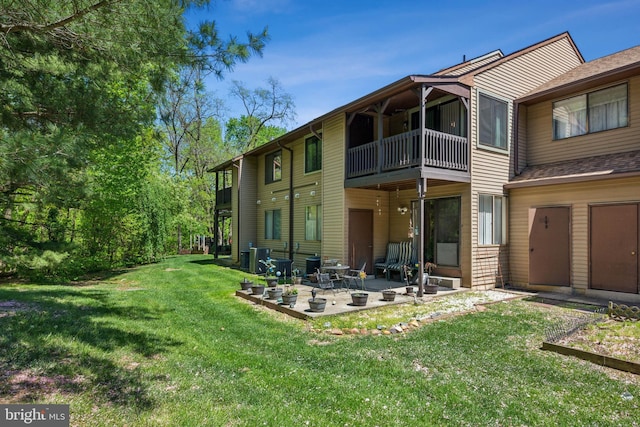 back of house with a lawn, central AC unit, a patio area, and a balcony