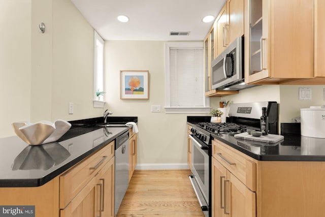 1320 Park Rd NW Unit 1, Washington, DC 20010 - kitchen with stainless steel appliances, a peninsula, a sink, baseboards, and light wood-style floors