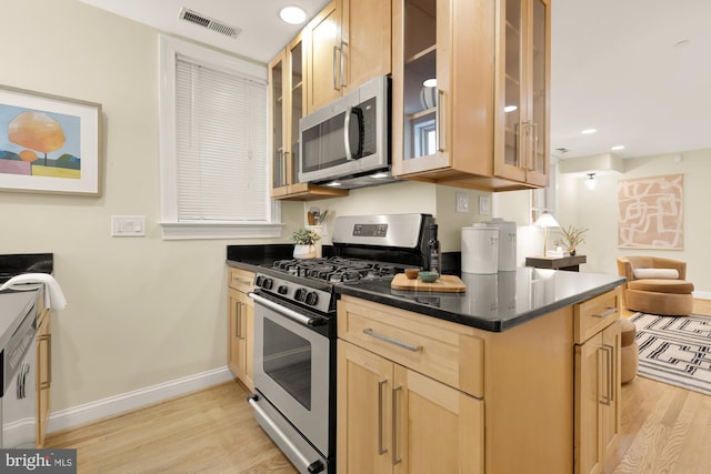 1320 Park Rd NW Unit 1, Washington, DC 20010 - kitchen with appliances with stainless steel finishes, light wood-style flooring, light brown cabinetry, baseboards, and glass insert cabinets