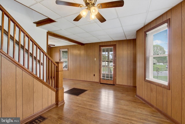 entryway featuring wooden walls, baseboards, wood finished floors, and stairway