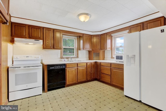 kitchen with a sink, light countertops, light floors, under cabinet range hood, and white appliances