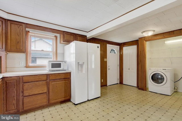 kitchen featuring white appliances, light countertops, washer / dryer, and light floors