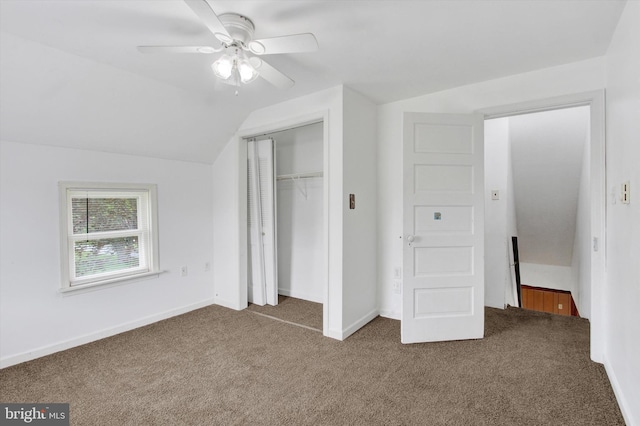 unfurnished bedroom with ceiling fan, carpet floors, baseboards, a closet, and lofted ceiling