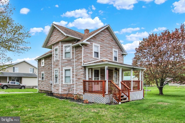 view of front of home featuring a porch, a front yard, and a chimney