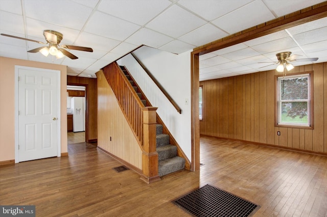 interior space featuring visible vents, a ceiling fan, baseboards, and wood finished floors